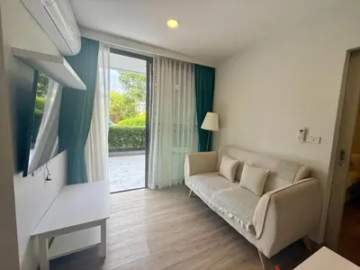a living room with a couch and a sliding glass door at Laguna cozy 2 bedroom apartment 5min to the beach in Laguna Phuket