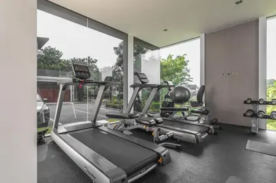 a gym with two tread machines in a room with windows at V217 Brand New 3BR Villa Near Beach & Boat Avenue in Thalang