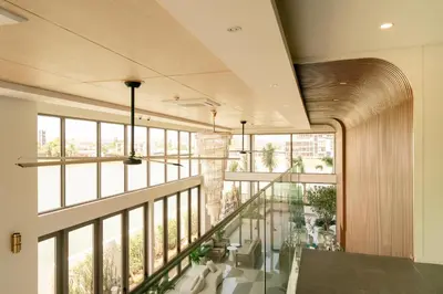 a large room with a balcony with windows at Lakefront suite The Aqua at Boat avenue in Bang Tao Beach
