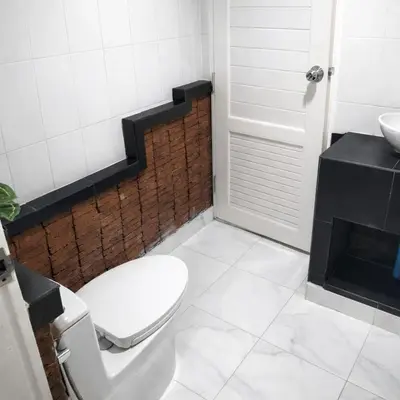 a bathroom with a white toilet and a sink at Earth House HomeStay Bangjo in Ban Pak Lak