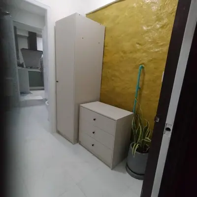 a room with a white cabinet and a yellow wall at Earth House HomeStay Bangjo in Ban Pak Lak