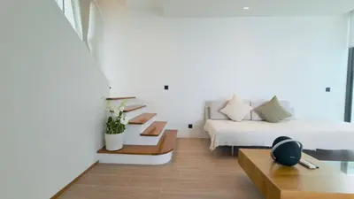 a living room with a bed and a couch at Phuvista Villas Naithon by Escape Villas - Brand New 3 BR Pool Villa - 500m from the beach in Phuket Town