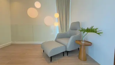 a living room with a chair and a stool at Phuvista Villas Naithon by Escape Villas - Brand New 3 BR Pool Villa - 500m from the beach in Phuket Town
