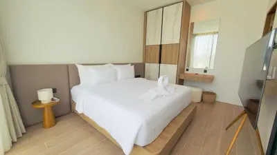 a bedroom with a white bed and a mirror at Phuvista Villas Naithon by Escape Villas - Brand New 3 BR Pool Villa - 500m from the beach in Phuket Town