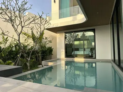 a house with a swimming pool next to a bedroom at Phuvista Villas Naithon by Escape Villas - Brand New 3 BR Pool Villa - 500m from the beach in Phuket Town