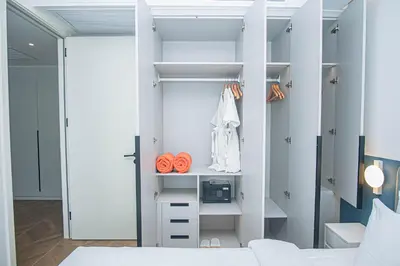 a bedroom with a white closet with orange handles at Coastal 1 bd apartment - Moments from the sea in Layan Beach