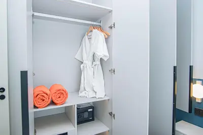 a closet with orange towels on a shelf at Coastal 1 bd apartment - Moments from the sea in Layan Beach