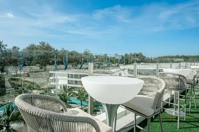 a group of chairs and a table on a balcony at Coastal 1 bd apartment - Moments from the sea in Layan Beach