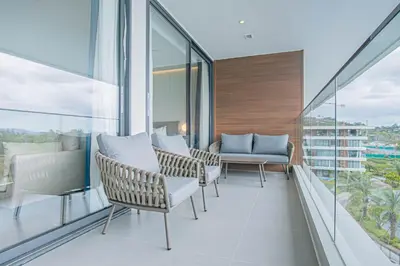 a balcony with chairs and a table and windows at Coastal 1 bd apartment - Moments from the sea in Layan Beach