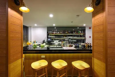 a bar with three stools in front of a counter at C109 Beachfront Seaside Escape Pool Access in Ban Saiyuan (1)