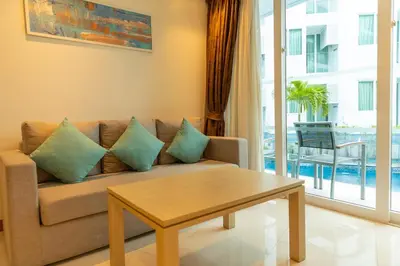 a living room with a couch and a table at C109 Beachfront Seaside Escape Pool Access in Ban Saiyuan (1)