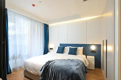 a bedroom with a large white bed with blue pillows at 2BR Layan Beach Apartment Capital Pro Kora D244 in Layan Beach