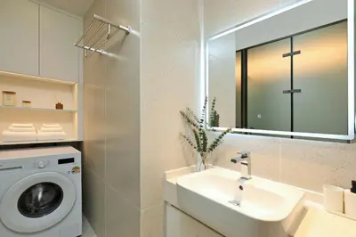 a bathroom with a washing machine and a sink at 2BR Layan Beach Apartment Capital Pro Kora D244 in Layan Beach