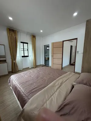a large bedroom with a large bed and two windows at Bancha white house in Ban Bo Han