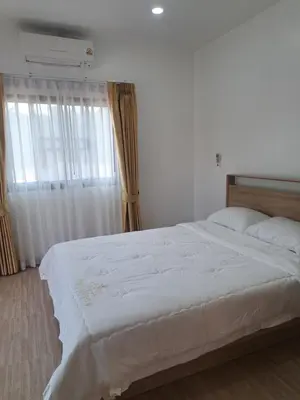 a bedroom with a large white bed with a window at Bancha white house in Ban Bo Han