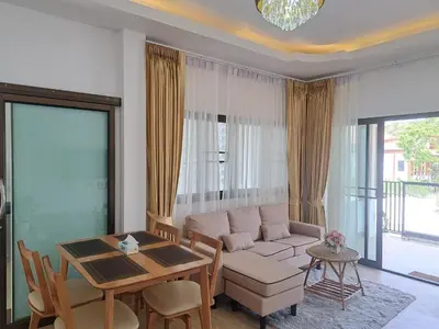 a living room with a couch and a table at Bancha white house in Ban Bo Han