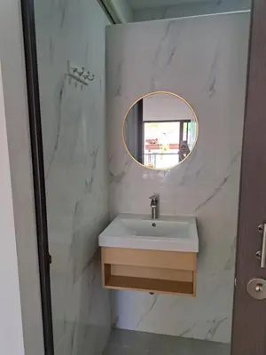 a bathroom with a sink and a mirror at Bancha white house in Ban Bo Han