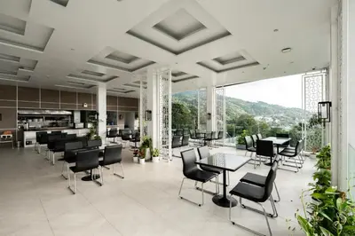 a lobby with chairs and tables and windows at Seavale patong phuket in Patong Beach