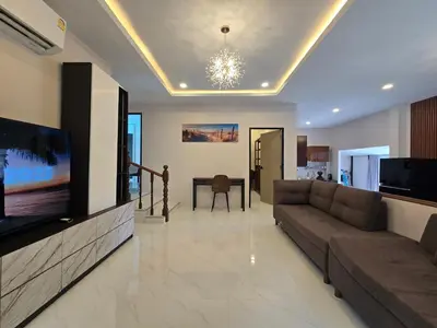 a living room with a couch and a flat screen tv at Kathu V pool villa soi Srikor in Ban Kathu