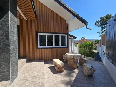a patio with two benches and a building at Kathu V pool villa soi Srikor in Ban Kathu