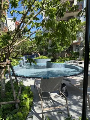 a swimming pool in the middle of a building at Canvas Cherngtalay New 2BR Pool View Apartment in Laguna Phuket