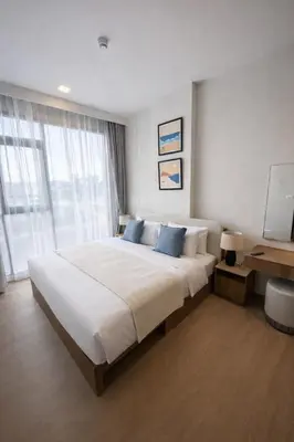 a bedroom with a large white bed with blue pillows at 2BR Apartment, 10-Min Walk to the Beach in Laguna Phuket