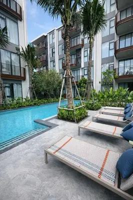 a hotel with a swimming pool and palm trees at 2BR Apartment, 10-Min Walk to the Beach in Laguna Phuket