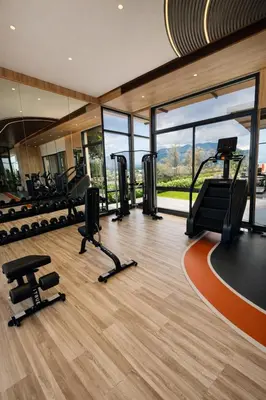 a gym with treadmills and cardio equipment in a building at 2BR Apartment, 10-Min Walk to the Beach in Laguna Phuket