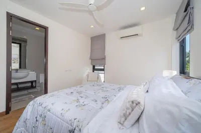 a white bedroom with a bed and a bathroom at Lux Laguna Park 5 bedroom rooftop pool in Laguna Phuket
