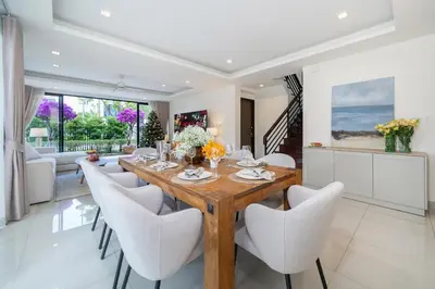 a dining room with a wooden table and chairs at Lux Laguna Park 5 bedroom rooftop pool in Laguna Phuket