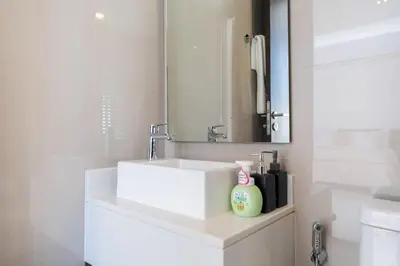 a bathroom with a white sink and a mirror at Lux Laguna Park 5 bedroom rooftop pool in Laguna Phuket