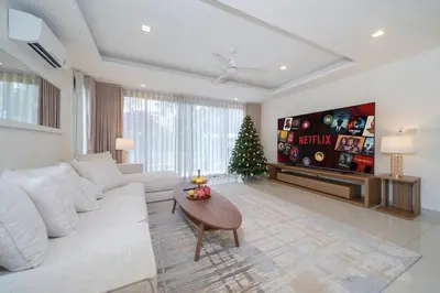 a living room with a white couch and a christmas tree at Lux Laguna Park 5 bedroom rooftop pool in Laguna Phuket