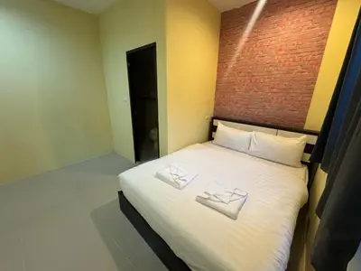 a bedroom with a bed with two white pillows on it at Luxus Guesthouse in Patong Beach