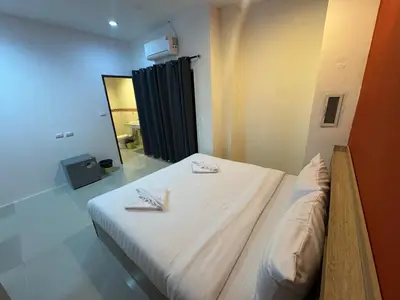 a bedroom with a bed with two towels on it at Luxus Guesthouse in Patong Beach