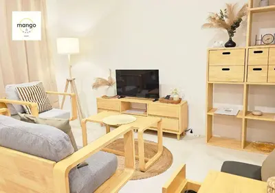 a living room with a couch and a tv at Mango Moon Phuket Art Haus 1 BR Near Central Phuket in Ban Nong Chaeng