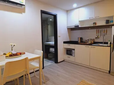 a kitchen with a table and a dining room at The title Aparthotel by Perfect Rawai Holiday Homes in Rawai Beach