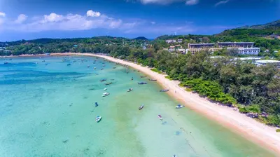 an aerial view of a beach with people in the water at The title Aparthotel by Perfect Rawai Holiday Homes in Rawai Beach