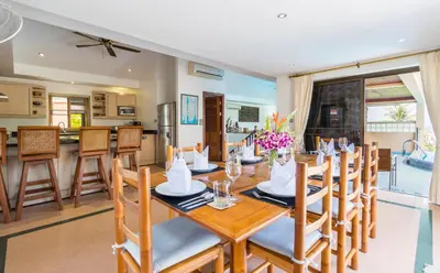 a dining room and kitchen with a table and chairs at Sea View Luxury Villas Kata Beach in Kata Beach