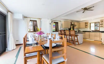 a kitchen and dining room with a wooden table and chairs at Sea View Luxury Villas Kata Beach in Kata Beach