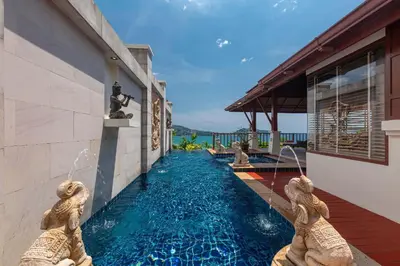 a swimming pool with two mermaid statues next to a building at Stunning Sea & Sunset Views Villa over Patong Bay in Patong Beach