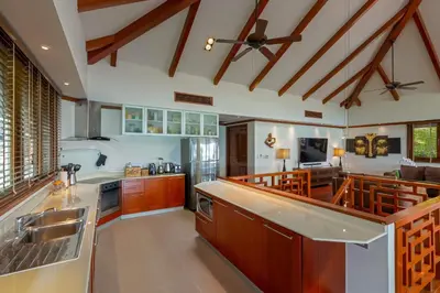 a large kitchen with wooden cabinets and a ceiling at Stunning Sea & Sunset Views Villa over Patong Bay in Patong Beach