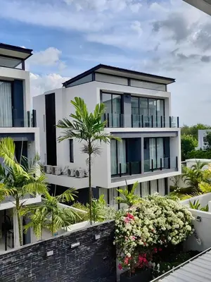 a large white building with palm trees and flowers at 6-Bedroom Villa in Laguna Park 2 Phuket in Ban Phru Champa