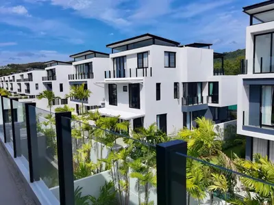 a row of white apartment buildings with palm trees at 6-Bedroom Villa in Laguna Park 2 Phuket in Ban Phru Champa