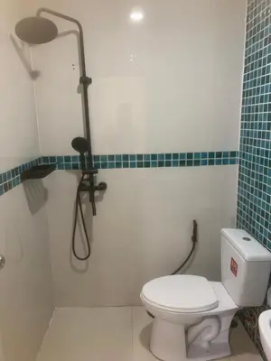 a bathroom with a white toilet and a shower at Nai Yang Guest House in Nai Yang Beach