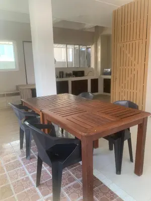 a wooden table and chairs in a room at Nai Yang Guest House in Nai Yang Beach