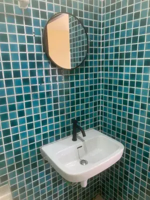a blue tiled bathroom with a sink and a mirror at Nai Yang Guest House in Nai Yang Beach