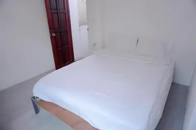 a white bed in a white room with a person holding it at XX Bao Patong Beach - เบา ป่าตอง ภูเก็ต in Patong Beach
