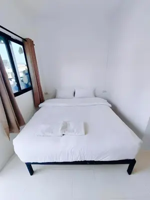 a white bed in a room with a window at XX Bao Patong Beach - เบา ป่าตอง ภูเก็ต in Patong Beach