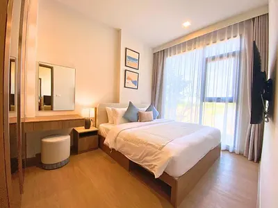 a hotel room with a bed and a mirror at New 2 Br Apartment Cherng talay in Laguna Phuket