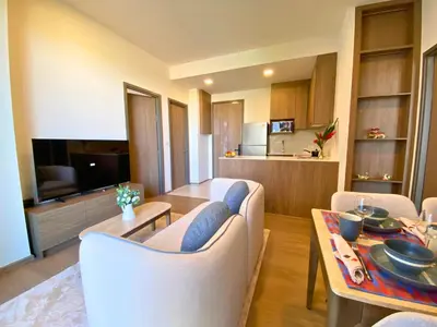 a living room with a couch and a dining room at New 2 Br Apartment Cherng talay in Laguna Phuket